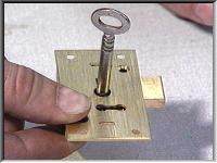 A finished brass cabinet lock